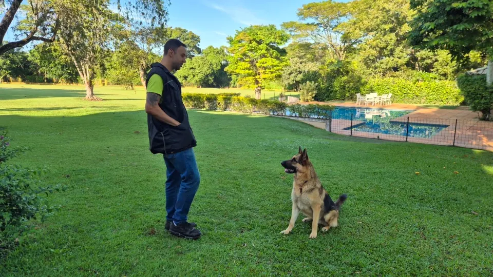 Pastor sentado no gramado olhando para o Ricardo