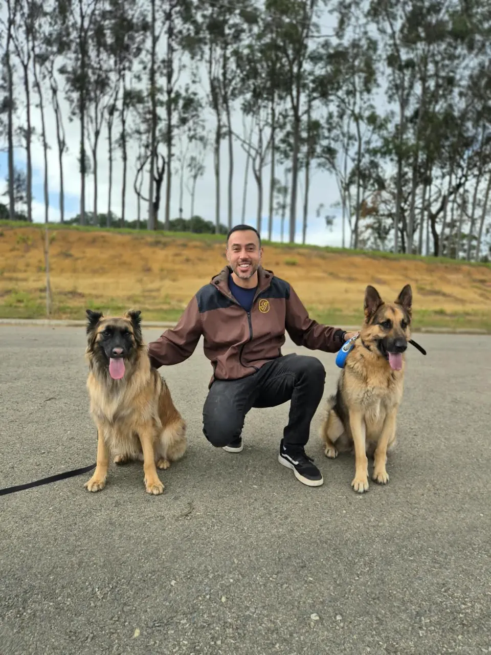 Ricardo agachado entre dois pastores na estrada