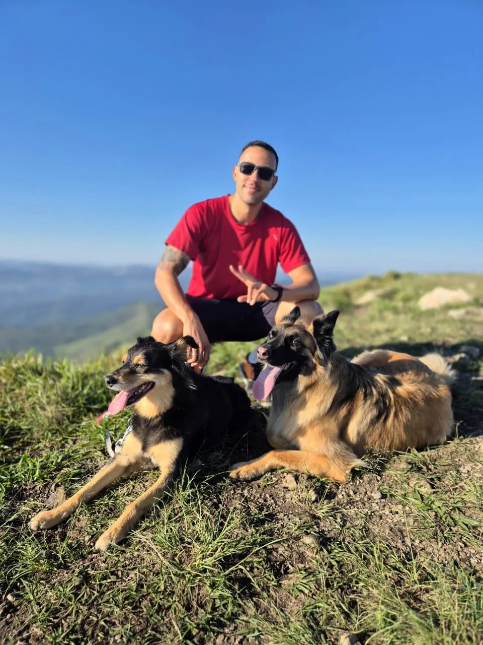 Ricardo com dois cães no alto de uma montanha