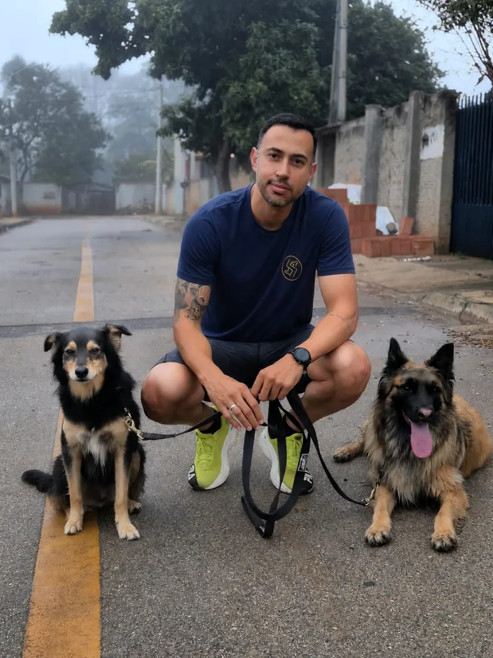 Ricardo agachado na rua com dois cães